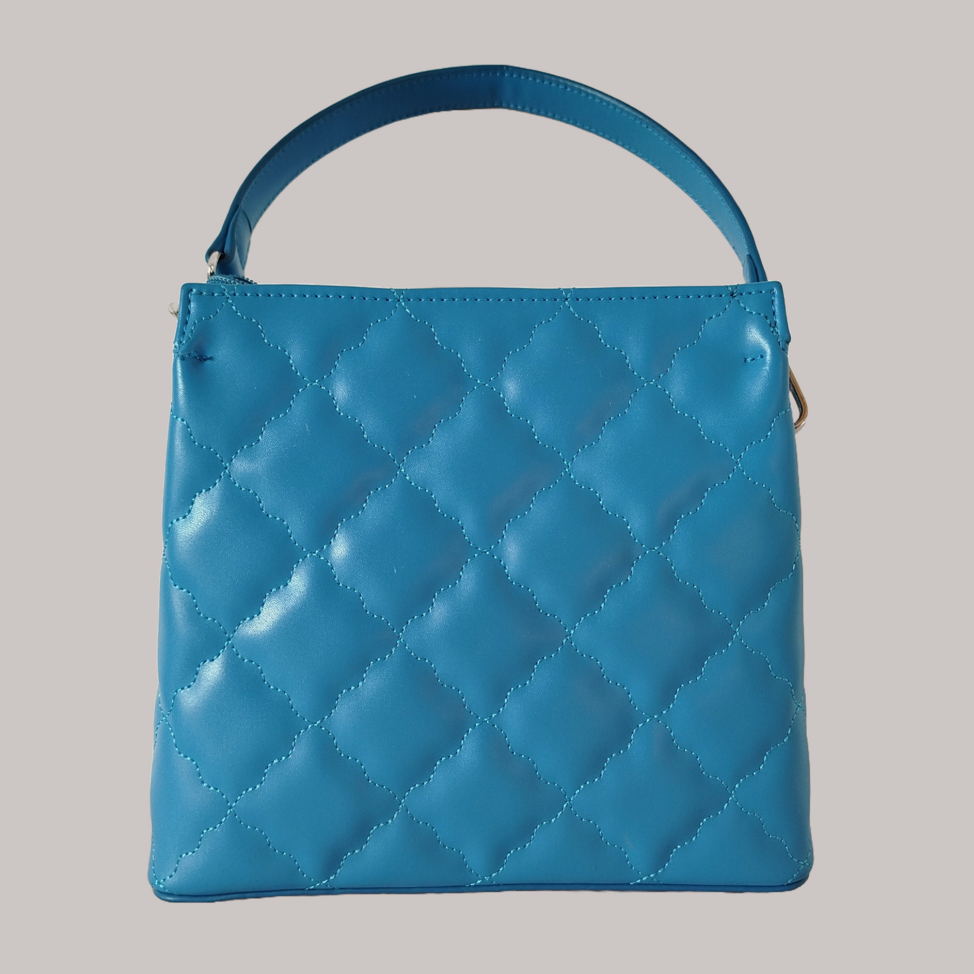 Women's blue trapezoid shaped quilted handbag with wavy diamond stitch